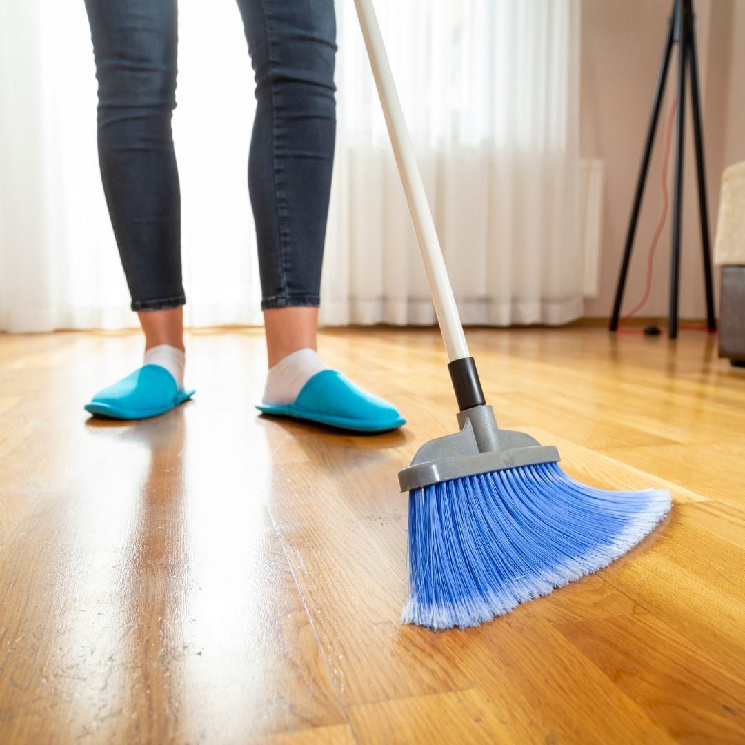 woman sweeping wood floor