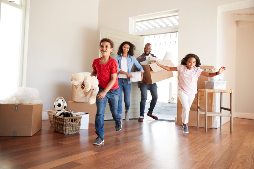 Excited family carrying boxes into new home on moving day in Northern Virginia